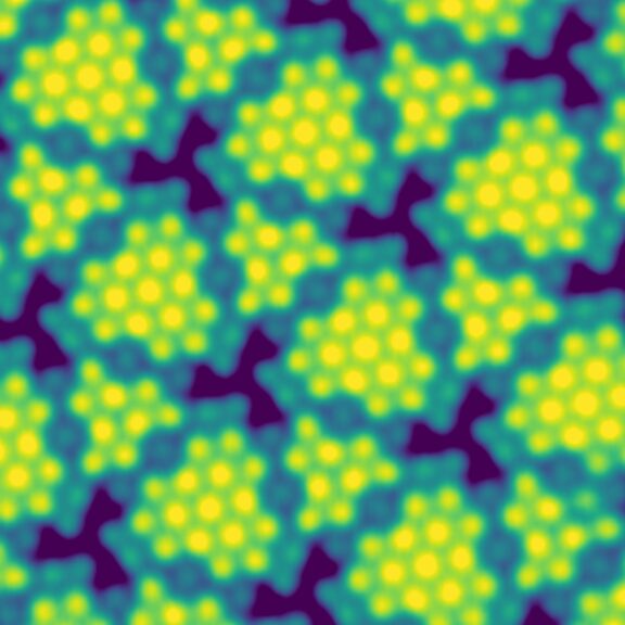 Das Bild zeigt eine Mikroskopieaufnahme von Tellarium Atomen, welche als leuchtende grün-gelbe Punkte in kleinen Gruppen zusammenhängen. Sie befinden sich auf einer Gold-Unterlage, welche dunkelblau und türkies durch die Atomgruppen hindurch schimmert.